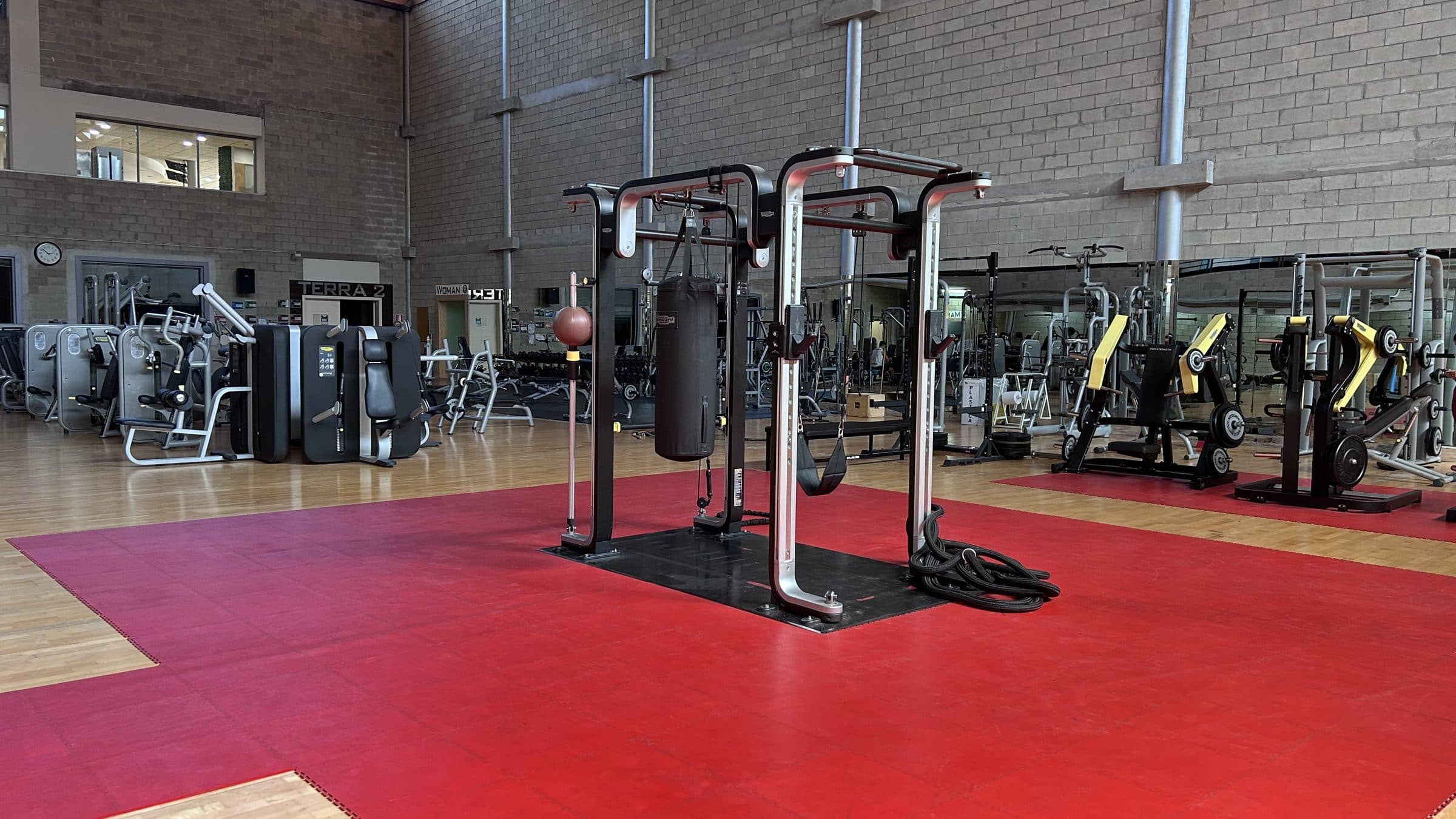 Il Gym Floor, con l'area funzionale sul pavimento rosso e le macchine intorno